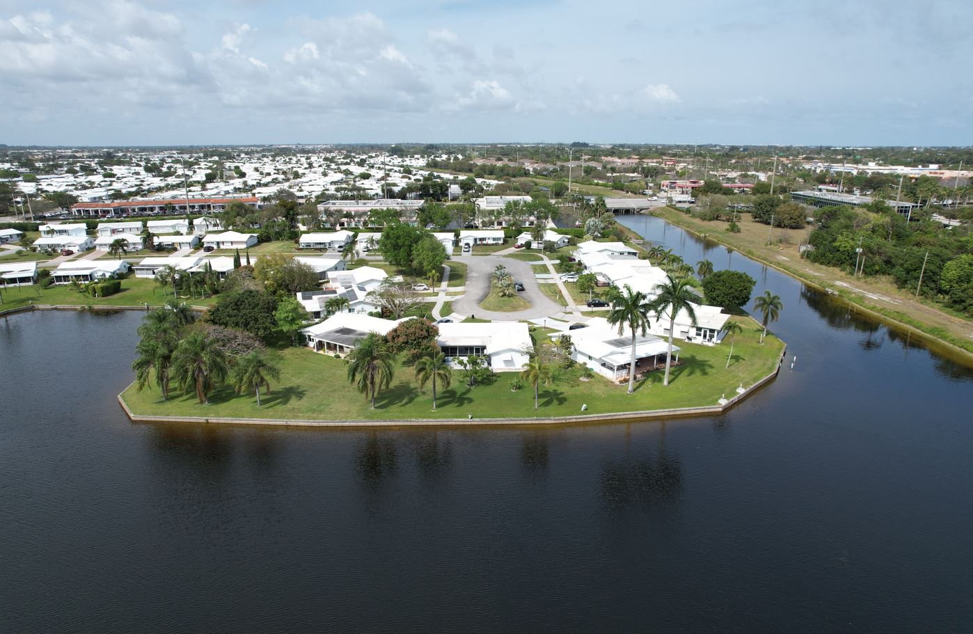 Aerial view of a small island surrounded by blue water, showcasing the natural beauty of Boynton Beach.