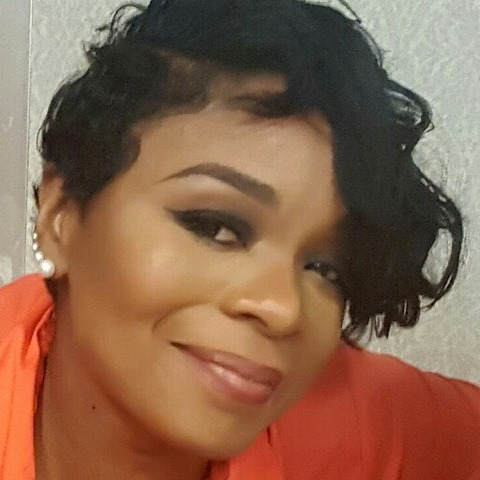 A woman named Zellena Johnson with short hair wearing an orange shirt.