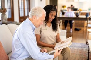 A woman and an older man relax on a couch, each reading a magazine, sharing a quiet moment.
