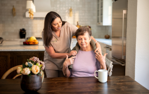A younger woman is gently helping an older woman with her hair, showcasing a moment of care and connection.