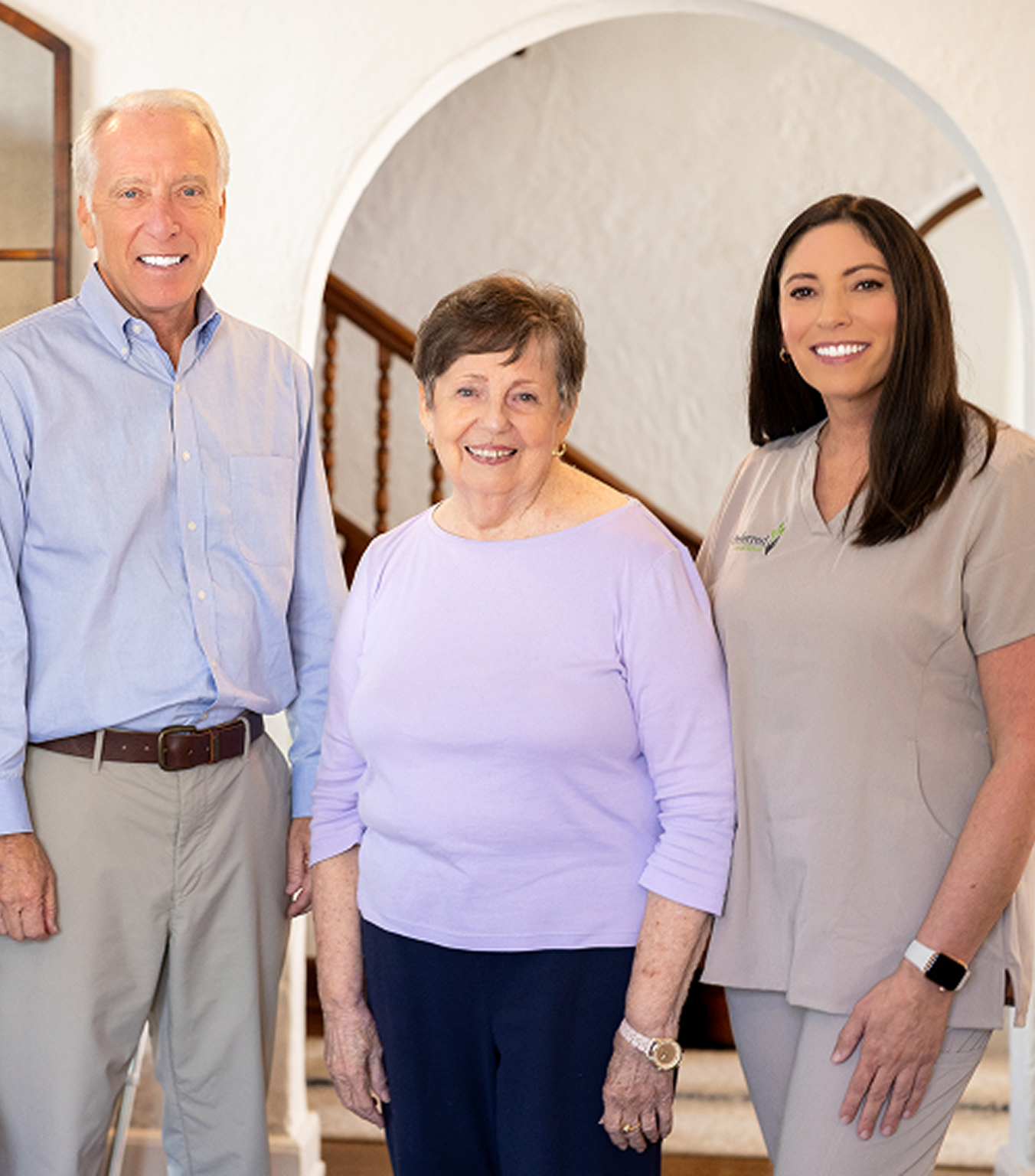 Three people by a doorway, sharing insights on caregiving techniques for families affected by Alzheimer's and dementia.