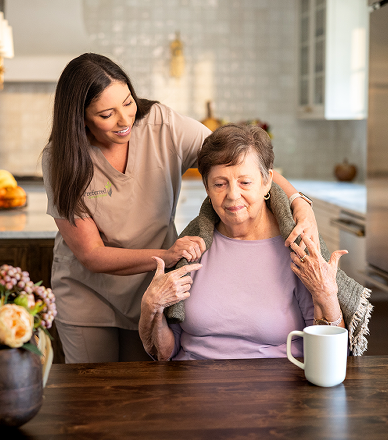 A caregiver helps an older woman with her hair, emphasizing dignity and tailored assistance in dementia care.