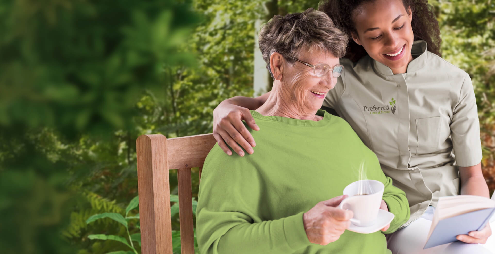 An image of a caregiver from Preferred Care at Home assisting an elderly individual with reading while she enjoys a cup of tea. Preferred Care at Home is a top-rated in-home care provider in Naples, FL, and nearby areas.